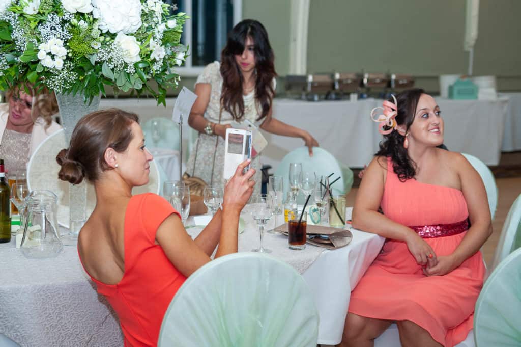 wedding guest takes a picture on her phone