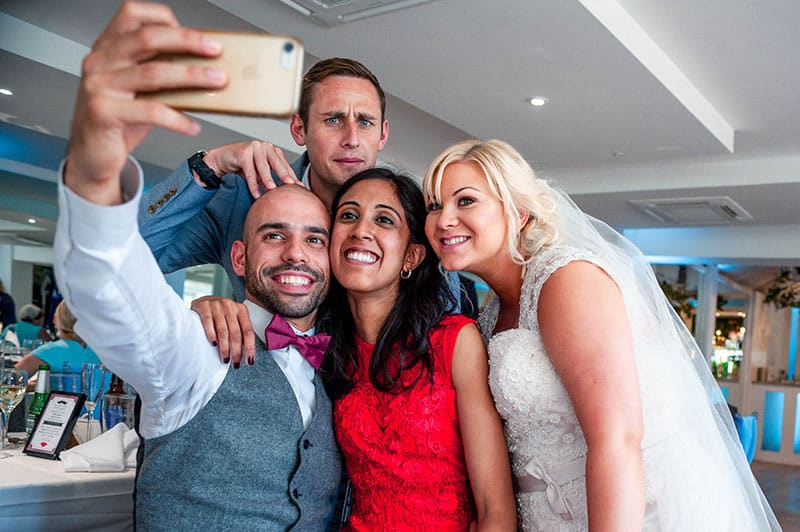 wedding guests and bride taking a selfie