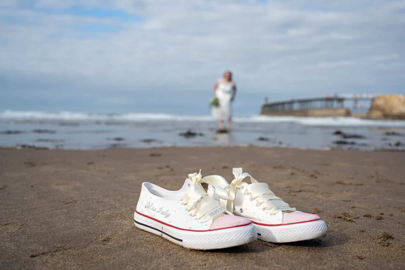 Whitby Beach and wedding trainers with bride standing in the sea